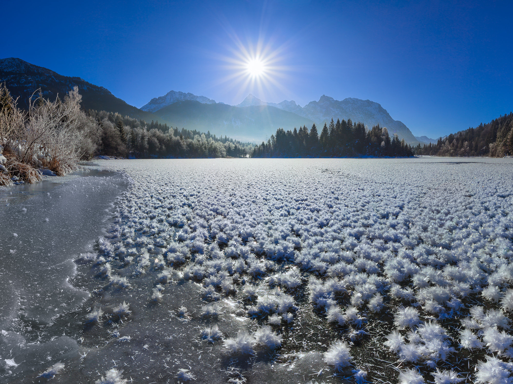 Eisblumen im Winter in den Alpen. Zugefrorener See.