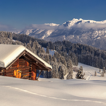 Verschneite Hütte unterhalb der Elmauer Alm im Winter